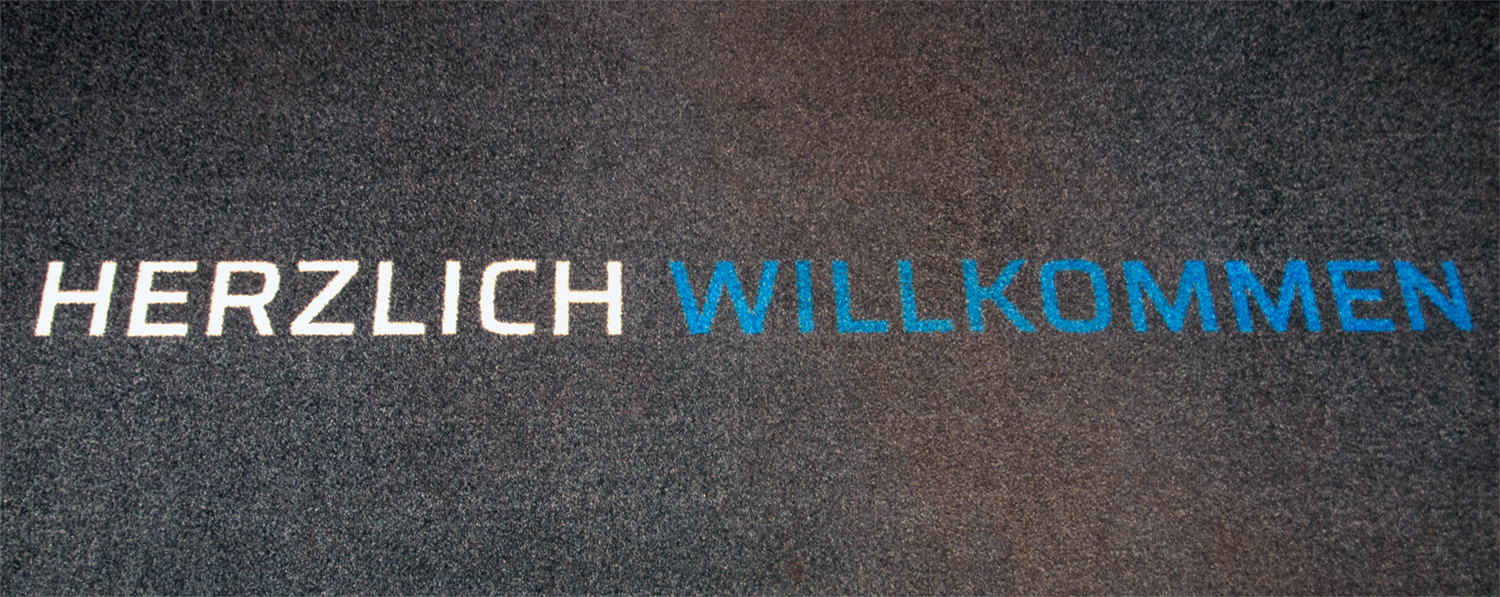 Teppich im Eingang mit Aufdruck "Herzlich Willkommen"